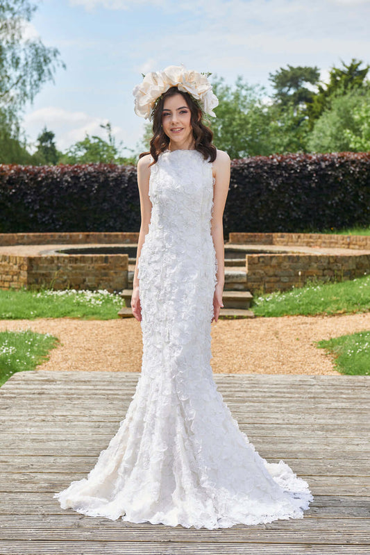 Myriss Wedding Dress featuring 3D floral appliques, model wearing gown in outdoor setting with flower crown.