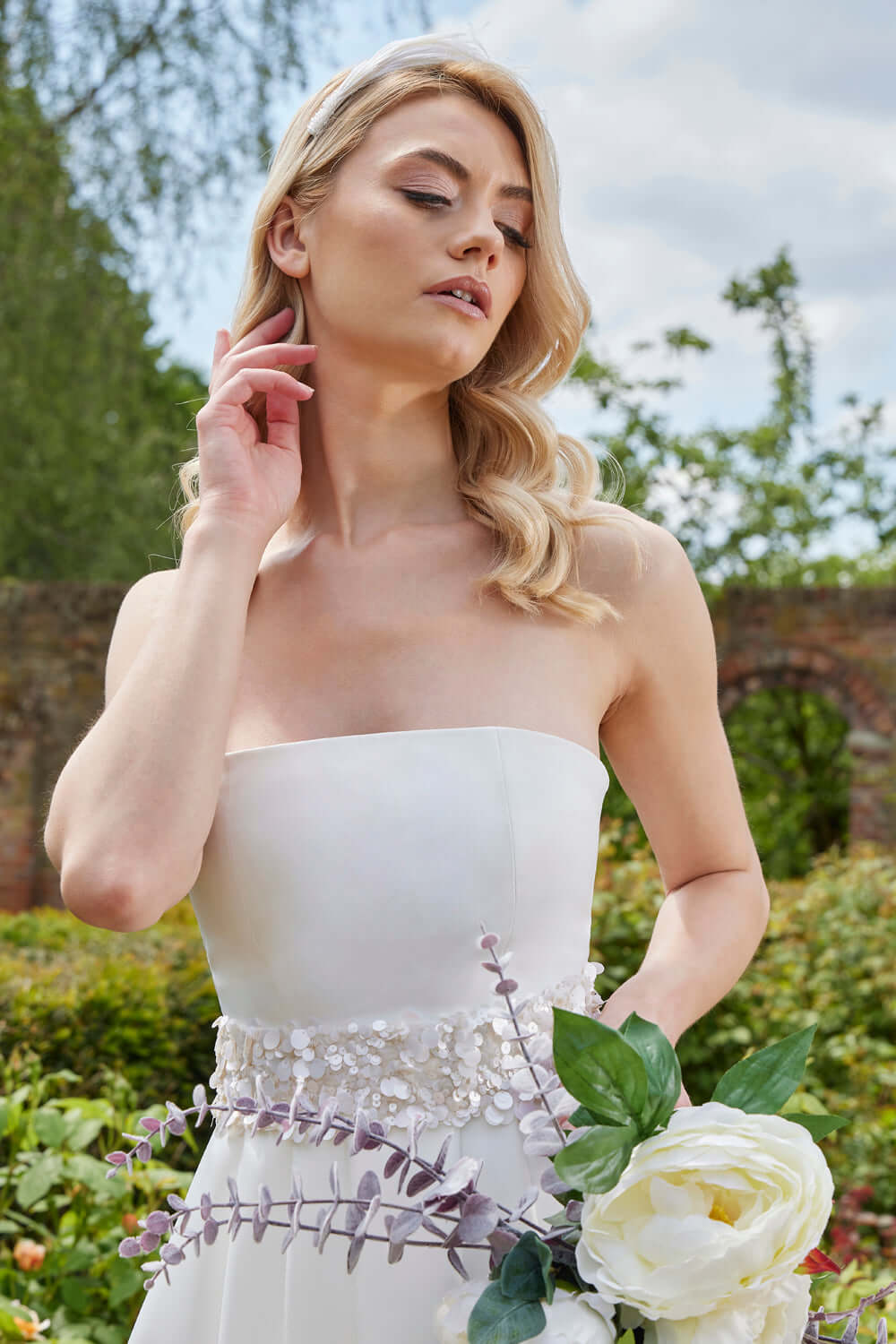 The Lysandra Wedding Dress features a chic strapless design that showcases your silhouette beautifully