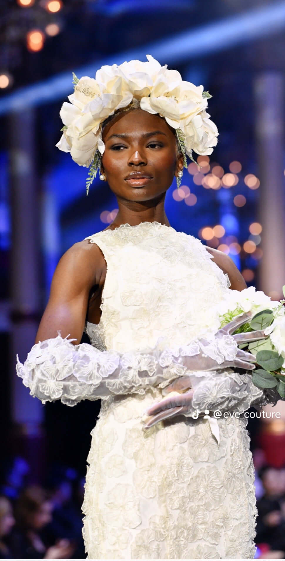 Myriss Wedding Dress featuring 3D floral appliques, worn by a model at a fashion show.