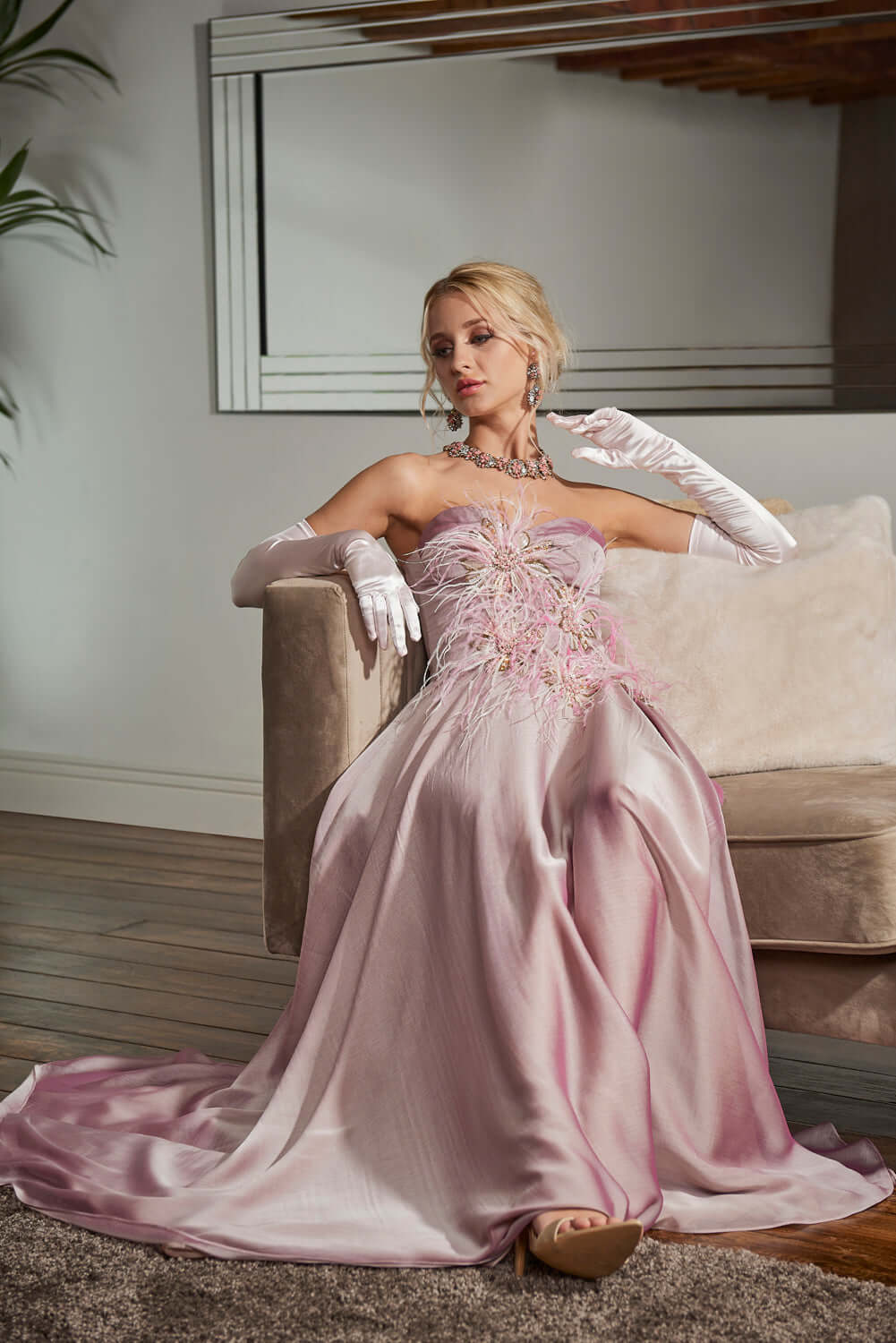 Dahlia Ball Gown - Iridescent Pink Dress with Feather, elegantly styled on model in indoor setting.