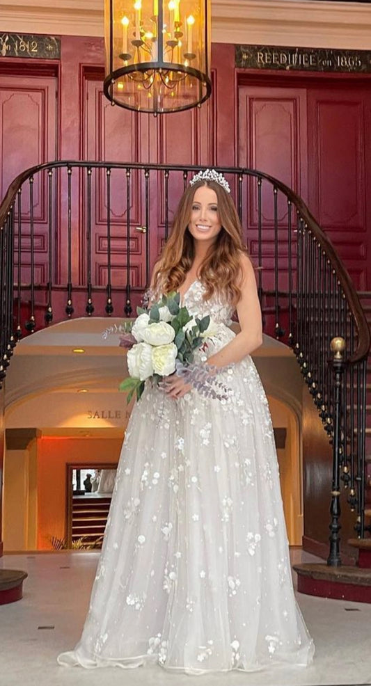 A stunning bride models the Antheia Wedding Dress by Eve Couture London in a grand interior setting. The luxurious couture bridal gown, designed by a renowned bridal designer, is adorned with elegant embellishments, showcasing its custom craftsmanship. This high-end designer dress is perfect for brides who want to shine on their special day, embodying the essence of a couture bridal gown.