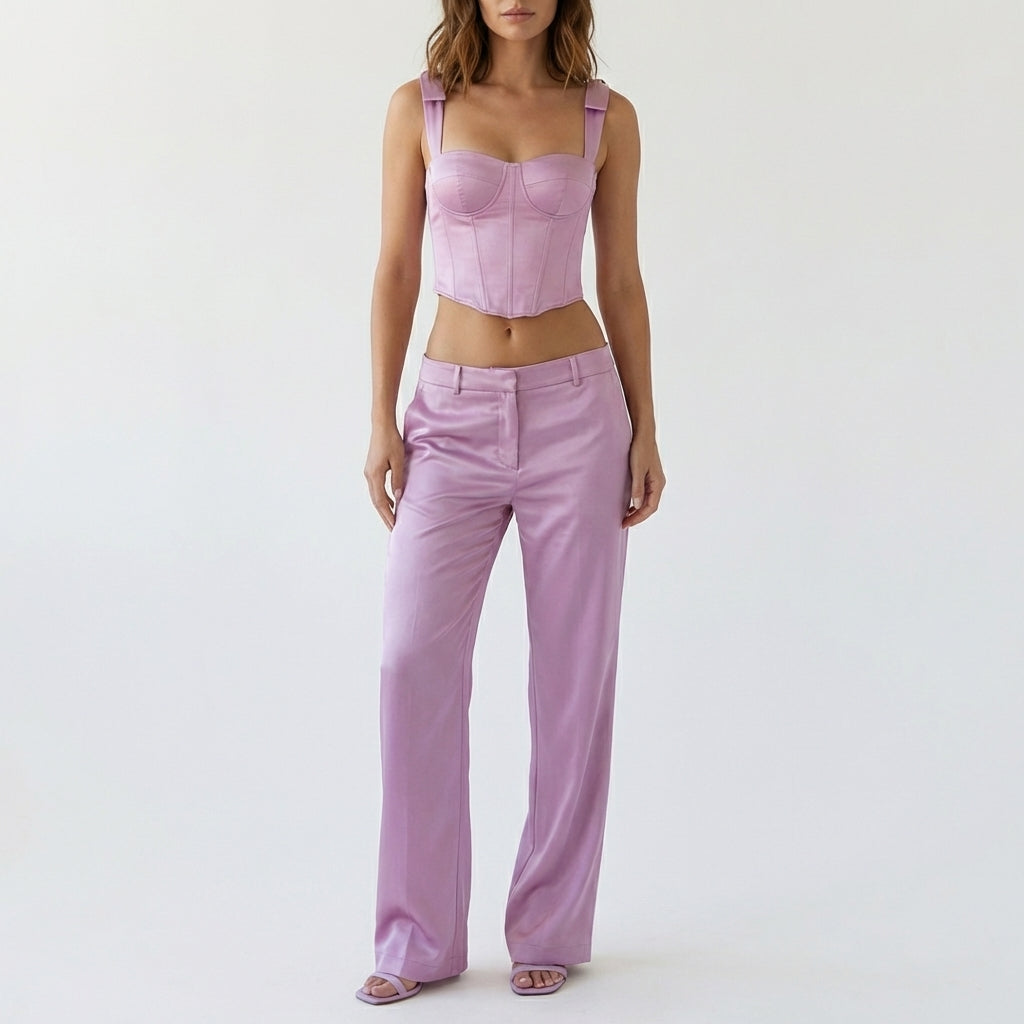 The Liv Corset Top & Low Waisted Trousers by Eve Couture are showcased in a soft light, crafted from elegant silk taffeta. This stunning co-ord set combines a structured corset with stylish trousers, perfect for eveningwear and made to order for individuality.